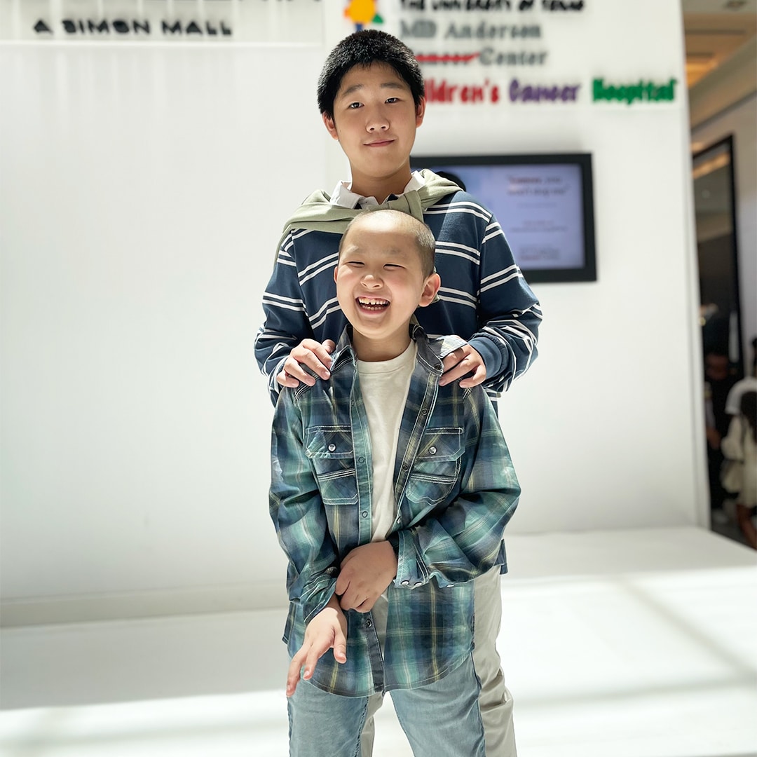 two boys standing together and smiling
