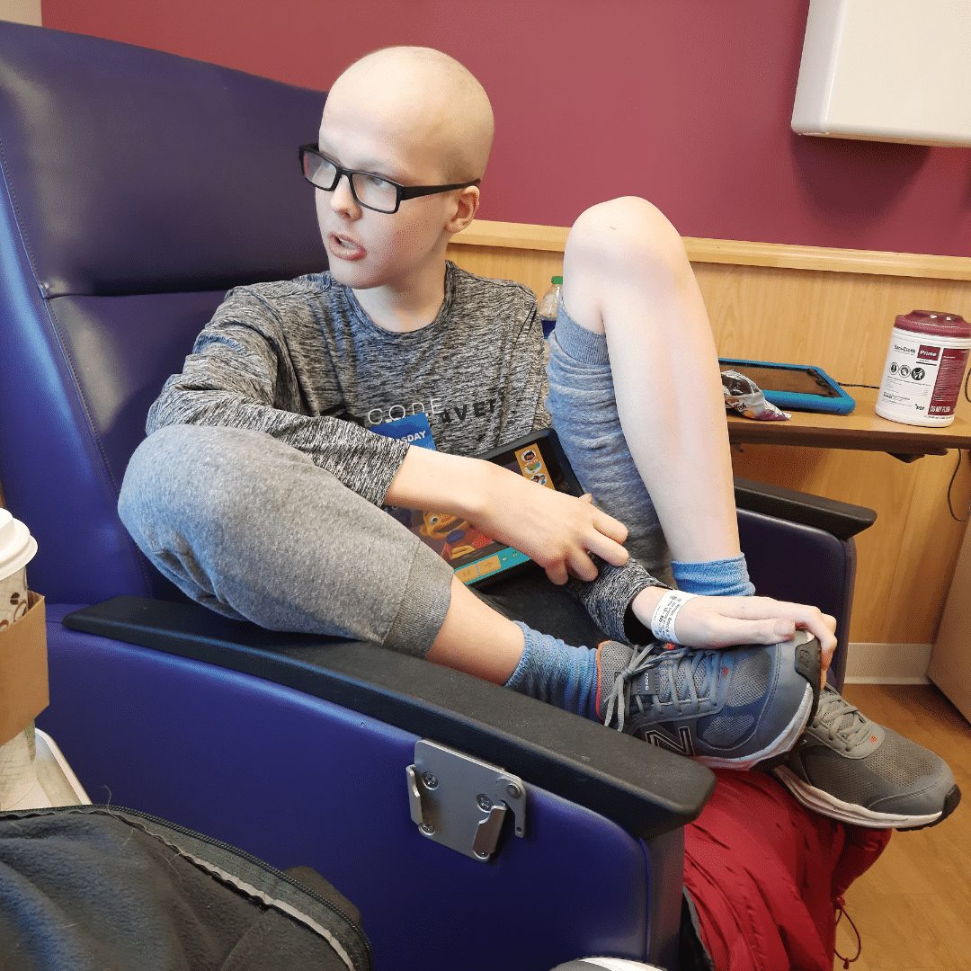 Ravi Herndon, osteosarcoma patient, sitting in a purple chair