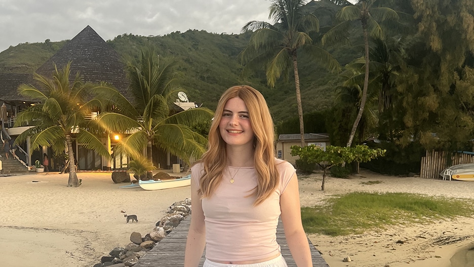 Addison Ryker standing on a pier at a beach in Tahiti