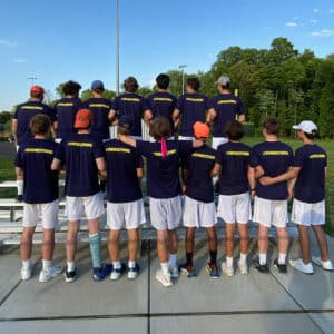 Sam Shumadine's tennis team wearing black shirts with their backs to the camera