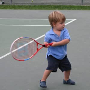 Young Sam Shumadine holding a tennis racket