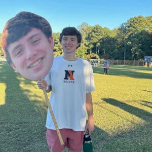 Sam Shumadine holding a large cutoff photo of his face