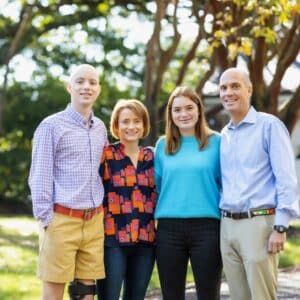Sam Shumadine and his family posing in front of a tree