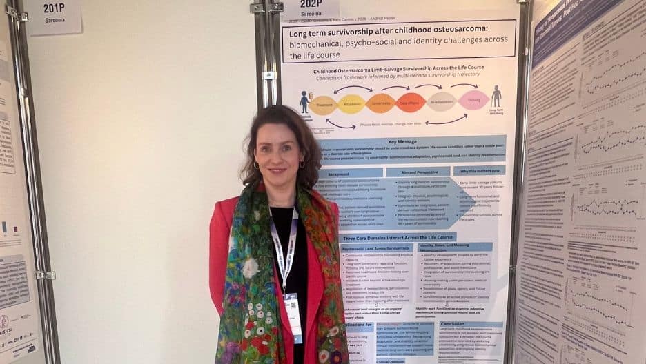 Osteosarcoma survivor Andrea Helfer in front of a presentation of her research.